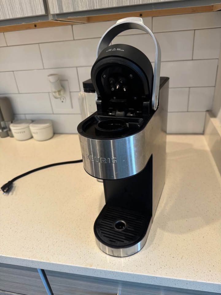 With the lid open you can reach the entrance needles above and the pod holder below. The exit needle is in the bottom of the holder.