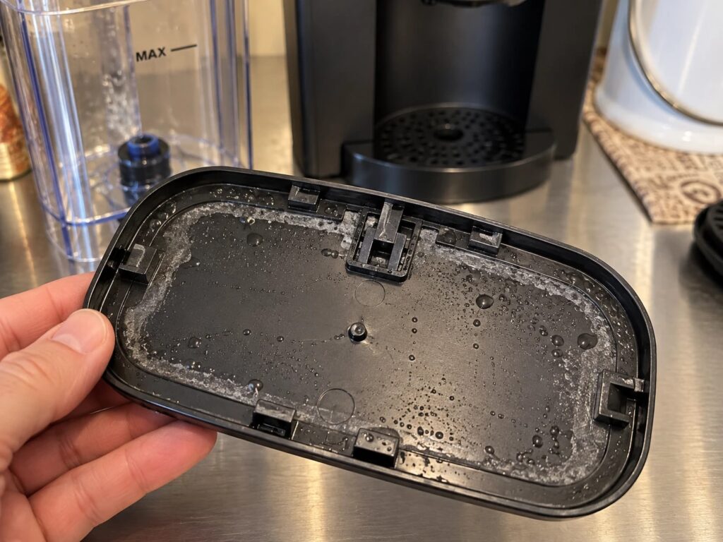 Underside of the reservoir lid: condensation plus a white mineral film along the rim.